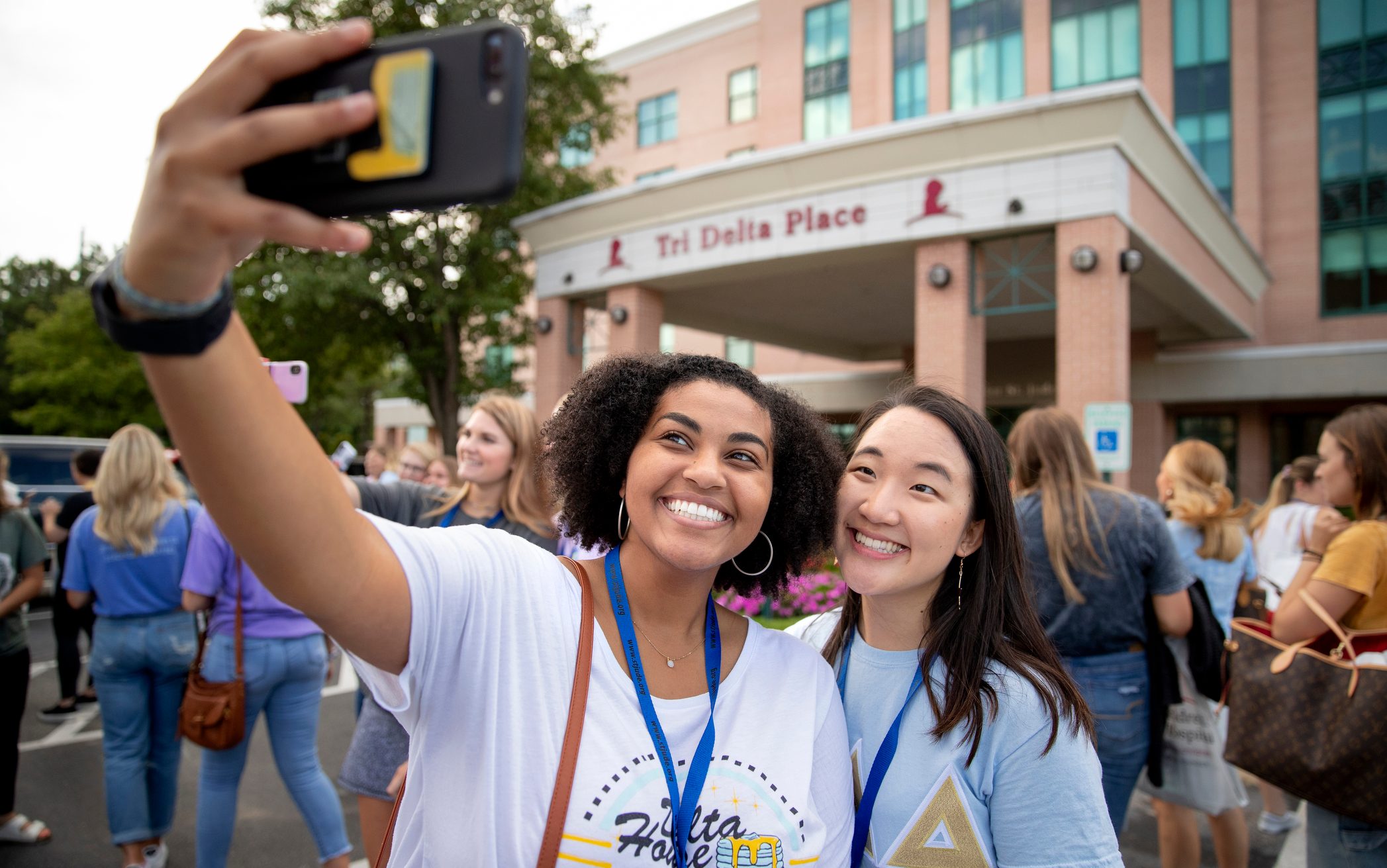 Two Tri Delta members take a selfie outside of Tri Delta Place.
