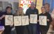 KMLE Phoenix radio staff hold a sign displaying $377k raised for St. Jude. 