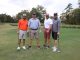 Four men on the standing on the golf course holding golf clubs