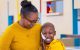 St. Jude patient Kenadie and her mom wear matching gold shirts and glasses.
